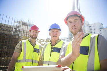 Drei Bauarbeiter mit digitalem Tablet auf einer Baustelle - ZEF001611