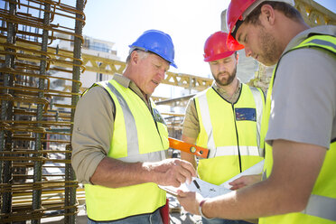 Construction workers discussing building plan in construction site - ZEF001631