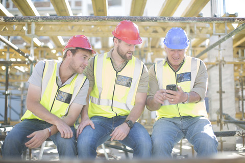 Bauarbeiter mit Handy in einer Pause, lizenzfreies Stockfoto
