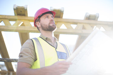 Construction worker holding plan at construction site - ZEF001657