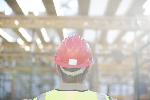 Bauarbeiter mit Schutzhelm auf einer Baustelle, lizenzfreies Stockfoto