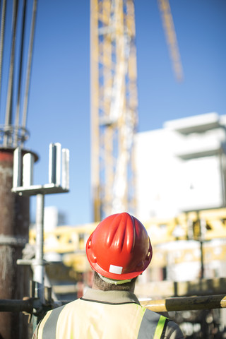 Bauarbeiter mit Schutzhelm auf einer Baustelle, lizenzfreies Stockfoto
