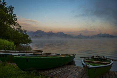 Deutschland, Bayern, Füssen, Morgenlicht mit Booten am Hopfensee, lizenzfreies Stockfoto