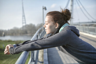 Junge Frau mit Herzfrequenzmessgerät entspannt sich nach dem Joggen - SEGF000067