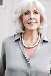 Porträt einer lächelnden weißhaarigen älteren Frau mit Bluse und Halskette - VRF000123
