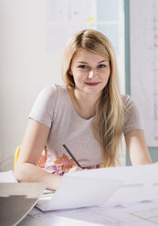 Porträt einer blonden jungen Frau am Schreibtisch - UUF002801