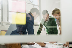 Three young architects in office discussing - UUF002810