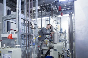 Young man in technical room checking appliance - SGF001196