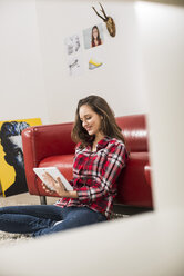 Smiling young woman using digital tablet at home - UUF002761