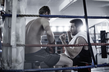 Ein Boxer macht eine Pause mit seinem Trainer in der Ecke des Boxrings - ZEF002504