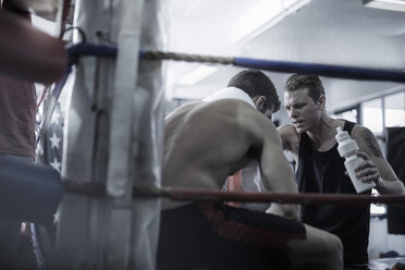 Boxer having a break with trainer in the corner of the boxing ring - ZEF002505