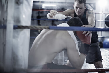 Ein Boxer macht eine Pause mit seinem Trainer in der Ecke des Boxrings - ZEF002506