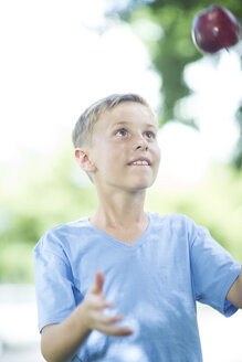Porträt eines Jungen, der mit einem Apfel jongliert - ZEF002737