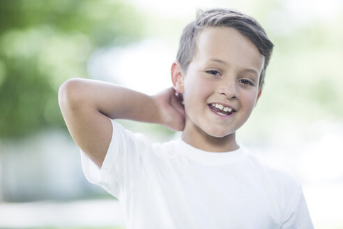 Porträt eines lächelnden Jungen mit der Hand hinter dem Kopf - ZEF002745