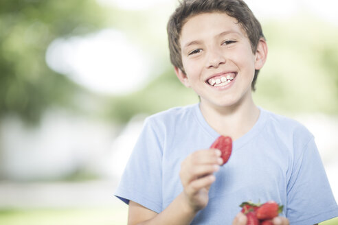 Porträt eines lächelnden Jungen mit Erdbeeren - ZEF002750