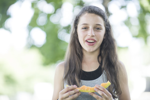 Porträt eines Mädchens, das eine Melone isst, lizenzfreies Stockfoto