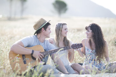 Südafrika, Freunde spielen Gitarre, sitzen im Feld - ZEF002598