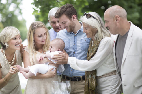 Familie versammelt sich um das Baby im Freien - ZEF003450