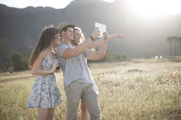 Südafrika, Freunde machen Selfie-Fotos mit Tablet im Feld - ZEF002612