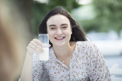 Glückliche junge Frau mit Milchschnurrbart im Freien, lizenzfreies Stockfoto