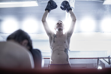 Boxing athlete standing victorious over his opponent - ZEF002638