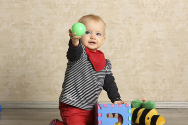 Baby-Mädchen mit Motorikspielzeug auf dem Boden - SHKF000047