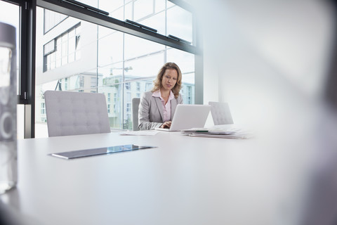 Geschäftsfrau mit Laptop im Konferenzraum, lizenzfreies Stockfoto