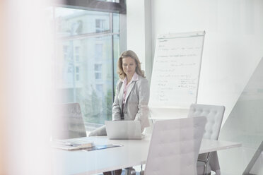 Businesswoman using laptop in conference room - RBF002118