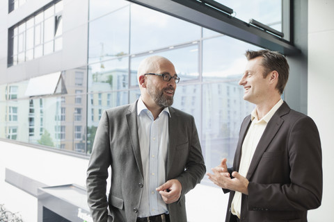 Two businessmen talking in office stock photo