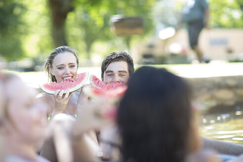 Freunde im Urlaub essen Wassermelone in einem Pool - ZEF003292