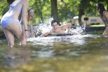 Freunde im Urlaub haben Spaß mit einem Schlauch in einem Pool - ZEF003294