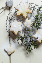 Selbstgebackene Weihnachtsplätzchen und Tannenzweig auf dem Kühlrost - SBDF002153