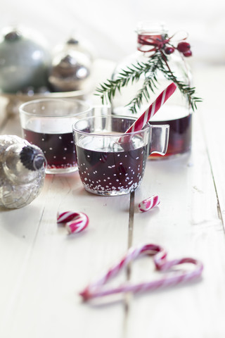 Gläser mit Glühwein, Zuckerstangen und Weihnachtsschmuck, lizenzfreies Stockfoto