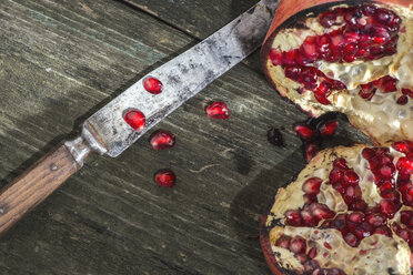 Sliced pomegranate and knife on wood - DEGF000060