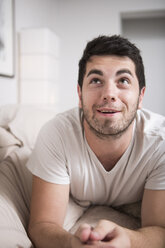 Porträt eines lächelnden Mannes, der zu Hause auf dem Bett liegt - ZEF002916