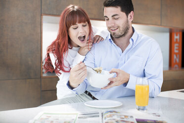 Ehepaar in der Küche beim Frühstück mit Orangensaft und Müsli - ZEF002641