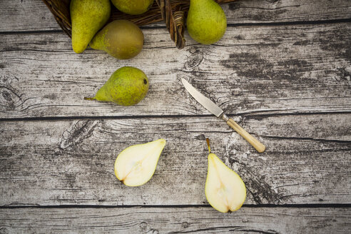 Ganze und geschnittene Bio-Birnen und ein Taschenmesser auf grauem Holz - LVF002467