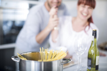 Ehepaar in der Küche bei der Zubereitung von Spaghetti in einem Topf - ZEF002675