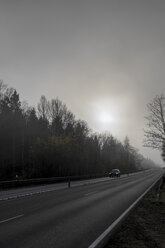 Germany, Eifel, car driving on Federal road in the fog - HLF000814