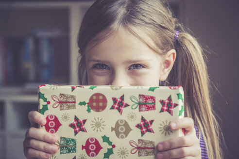 Little girl holding Christmas present - SARF001161