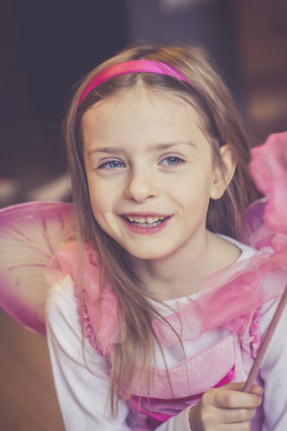 Porträt eines lächelnden kleinen Mädchens, das sich als Fee verkleidet hat, lizenzfreies Stockfoto