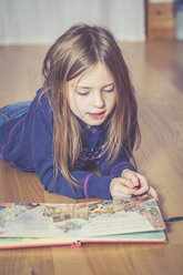 Litle girl lying on floor with songbook - SARF001154