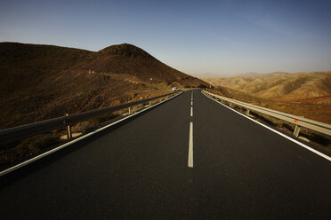 Spanien, Kanarische Inseln, Fuerteventura, Blick auf leere Straße bei Landschaft - STKF001106