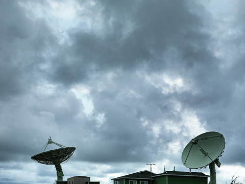 USA, Hawaii, Ka Lae, Satellitenschüsseln vor bewölktem Himmel, lizenzfreies Stockfoto