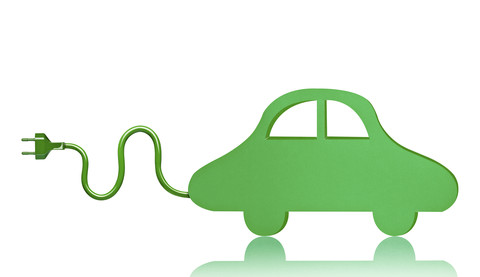 Green electric car toy in front of white background stock photo