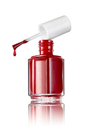 Bottle of red nail polish in front of white background - RAMF000016