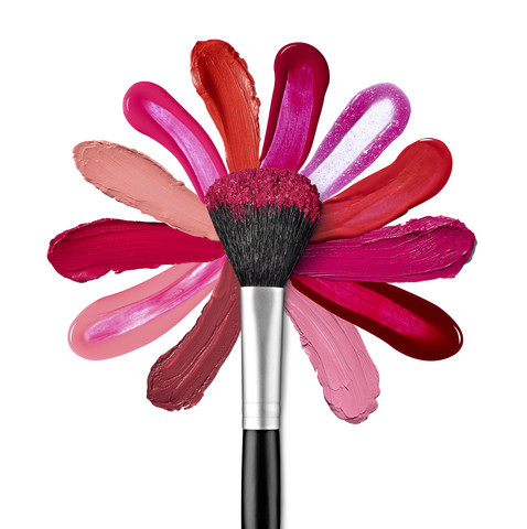 Lipstick and nail polish strokes forming with powder brush a flower shape stock photo