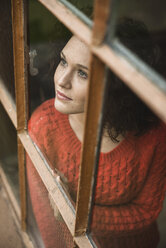 Young woman looking out of window - UUF002878