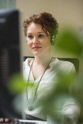 Young woman in office wearing headset - UUF002913