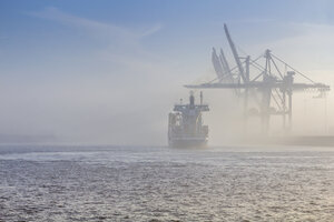 Deutschland, Hamburg, Containerschiff verschwindet im dichten Nebel im Hafen von Hamburg - NK000224
